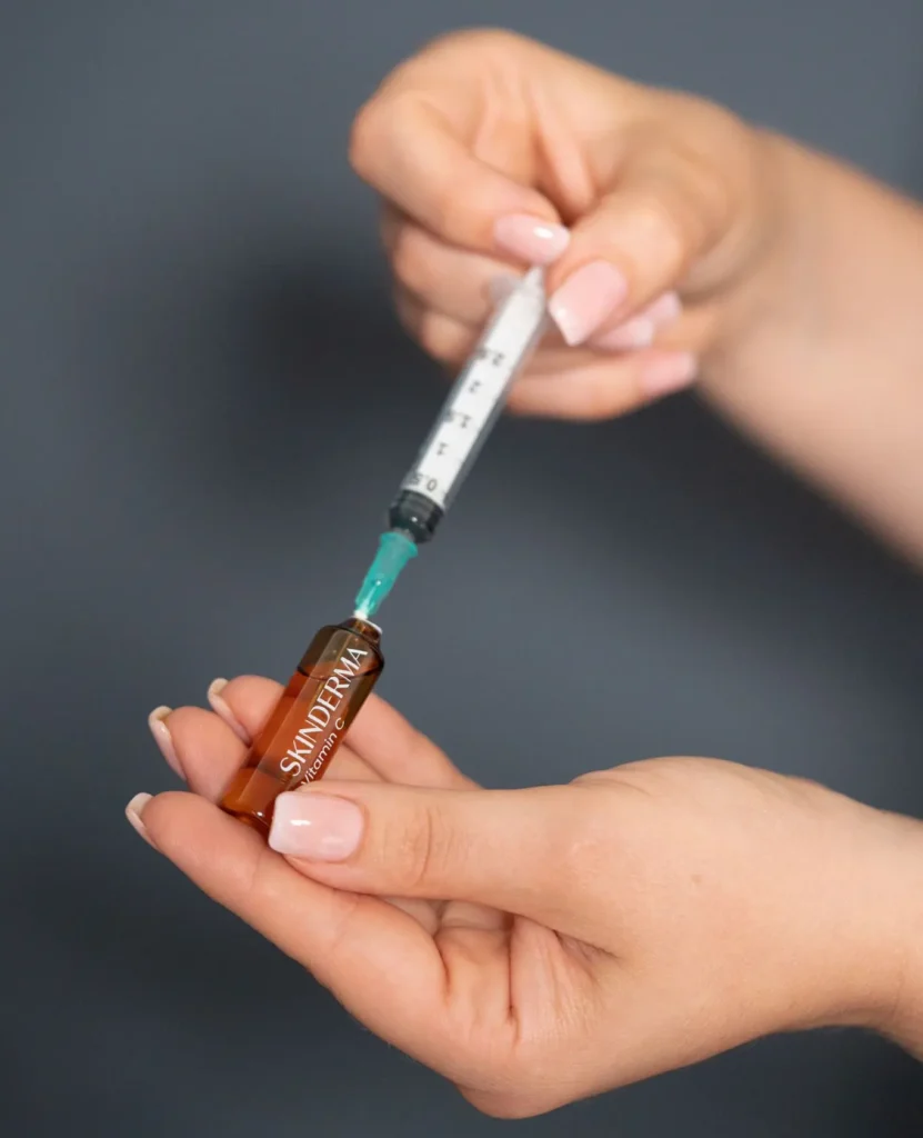 Vial con aguja en tratamiento facial